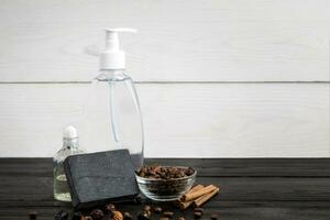 Spa still life. Aroma oils, stones, soap, shampoo and coffee beans on wooden background photo