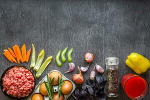 Composition of raw meat with vegetables and spice on wooden background photo