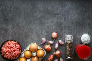 Composition of raw meat with vegetables and spice on wooden background photo