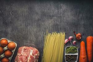 Raw meat beef with spaghetti, fresh organic vegetables, onion, garlic, spices, peppercorns, rosemary, salt and dill for cooking pasta. Top view. photo