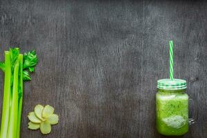 Green vegetable smoothie with celery, ginger and cucumber photo