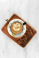 cappuccino coffee served in a white cup with black lines with coffee beans. isolated in white background photo