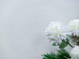 wooden background or white walls decorated with white flowers and green leaves with white space photo
