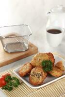 fried potato cheese balls croquettes with tomato ketchup served in a basket. white background and garnish photo