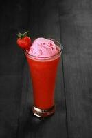 Strawberry juice with ice cream is served in a very luxurious clear glass. isolated in white and dark background photo