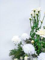 wooden background or white walls decorated with white flowers and green leaves with white space photo