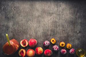 Peach and plums fruits smoothie in glass bottle and straws on wooden table. Healthy lifestyle. Toned photo