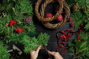 Manufacturer of Christmas decor with their own hands. Christmas wreath for the holiday. The new year celebration. Top view photo