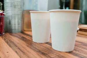 white paper cups of coffee mock up on blank background. two cups on table photo