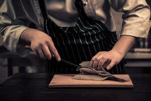 Chef cutting the fish on a board photo