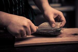 Chef cutting the fish on a board photo