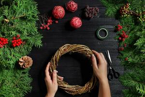 Manufacturer of Christmas decor with their own hands. Christmas wreath for the holiday. The new year celebration. Top view photo