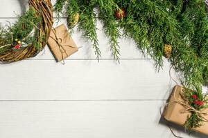 Make a Christmas wreath with your own hands. Spruce branch, Christmas wreath and gifts on a white wooden background photo