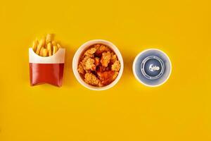 Fast food dish on yellow background. Fast food set fried chicken and french fries. Take away fast food. photo