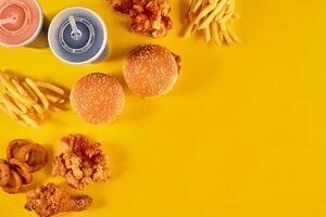 Fast food dish on yellow background. Fast food set fried chicken, meat burger and french fries. Take away fast food. photo