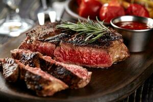 Juicy steak medium rare beef with spices on wooden board on table photo