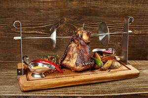 asado Cerdo nudillo eisbein con cocido a fuego lento hervido repollo, patatas y mostaza en de madera corte tablero foto