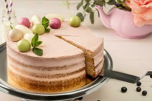 Pink cake with mint and decorative sweet balls from above on a plate, close-up. photo