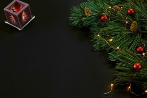 Christmas. Xmas toys and spruce branch on black background top view. Space for text photo