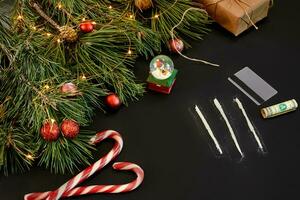 cocaína dividido dentro rutas con Navidad juguetes y abeto rama en negro antecedentes parte superior vista. foto