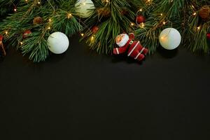 Christmas. Xmas toys and spruce branch on black background top view. Space for text photo