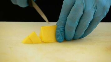 manos de cocinero o profesional cocinero corte un mango dentro dados video