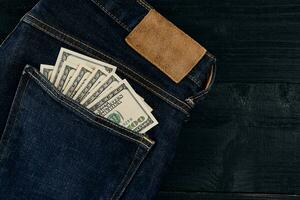 Pocket money. Dollar in hip pocket of worn blue jeans. Close-up. photo