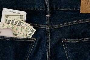 Dollars, smart and plane ticket in your pocket jeans. photo