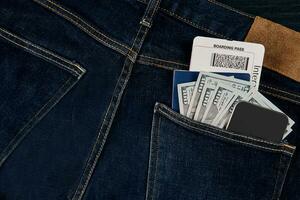 dólares, elegante, pasaporte y avión boleto en tu bolsillo vaqueros. foto