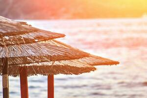 Sun loungers and umbrellas are on the beach in Budva, Montenegro. Sun flare photo