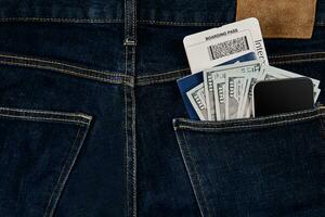 dólares, elegante, pasaporte y avión boleto en tu bolsillo vaqueros. foto
