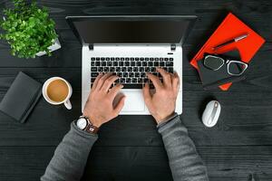 Directly above view of human hands typing on laptop. photo