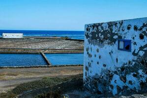 a small building with a blue window in front of the ocean photo