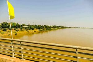 a yellow flag is hanging on a bridge over a river photo