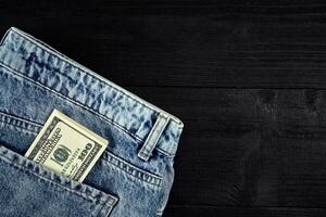 Pocket money. Dollar in hip pocket of worn blue jeans. Close-up. photo