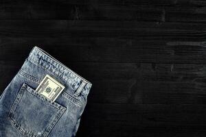 bolsillo dinero. dólar en cadera bolsillo de desgastado azul vaqueros. de cerca. foto
