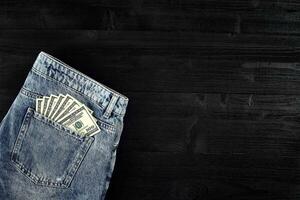 Pocket money. Dollar in hip pocket of worn blue jeans. Close-up. photo