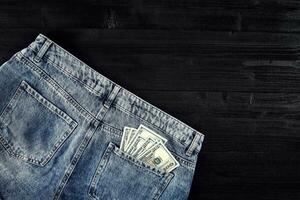 Pocket money. Dollar in hip pocket of worn blue jeans. Close-up. photo