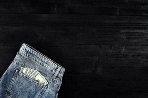 Pocket money. Dollar in hip pocket of worn blue jeans. Close-up. photo