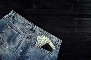 bolsillo dinero. dólar en cadera bolsillo de desgastado azul vaqueros. de cerca. foto