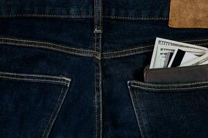 Money, Debit card and Credit card are in pocket of blue jean on wooden background with copy space. photo