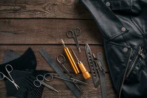 Leather craft or leather working. Leather working tools and cut out pieces of leather on work desk . photo