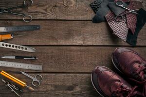 Leather craft or leather working. Leather working tools and cut out pieces of leather on work desk . photo