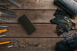 Leather craft or leather working. Leather working tools and cut out pieces of leather on work desk . photo