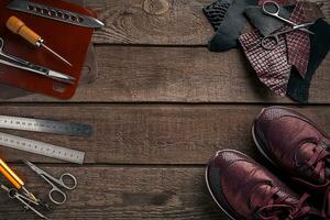 Leather craft or leather working. Leather working tools and cut out pieces of leather on work desk . photo