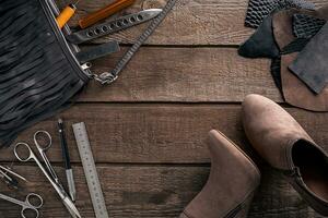 Leather craft or leather working. Leather working tools and cut out pieces of leather on work desk . photo