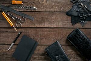 Leather craft or leather working. Leather working tools and cut out pieces of leather on work desk . photo