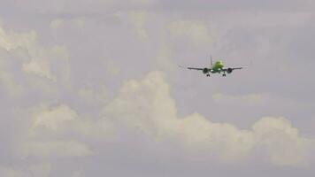 Passagier Flugzeug Annäherung zum Landung. Verkehrsflugzeug mit unkenntlich Grün Lackierung absteigend video