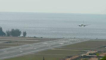 Runway in der Nähe von das Meer, Panorama- Sicht. Passagier Flugzeug Annäherung Landung beim das Flughafen auf ein tropisch Insel. Verkehrsflugzeug fliegt absteigend Über das Meer. Tourismus und Reise Konzept video