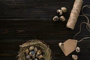 quail eggs in a nest, place for text on wooden rustic background top view close up photo